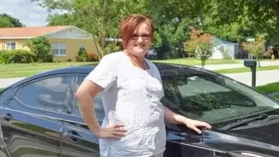 Polk State alumna Amy Eaton stands next to the new car she was able to purchase after graduating from Polk State free of student-loan debt.